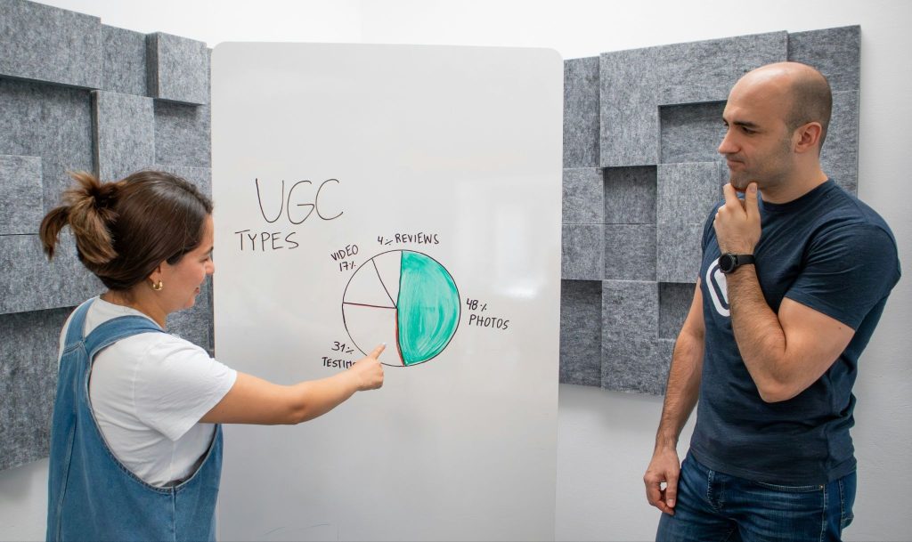 Two marketing professionals analyzing the stats of their UGC